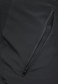 Schwarzer Stoff mit glatter Textur, der eine Reißverschlusstasche auf der rechten Seite aufweist. Der Reißverschluss ist schwarz mit kontrastierendem Stich entlang der Naht.