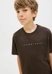Rudas medvilninis marškinėlis su apvalia apykakle ir trumpomis rankovėmis. Priekyje yra užrašas "JACK & JONES" balta didžiosiomis raidėmis.