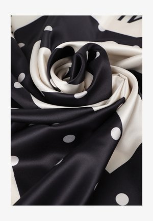 Tela de seda negra y crema, con grandes lunares blancos dispuestos en un patrón espiral, destacando su textura suave y brillante.