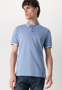 Svetlo modra polo majica s tremi gumbi, kontrastnim belim ovratnikom in obrobami rokavov, vezenim logotipom na prsih ter kratkimi rokavi.