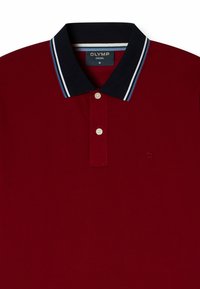 Polo shirt rossa in cotone, con colletto blu navy decorato da righe bianche e blu, apertura con tre bottoni e un discreto dettaglio del logo sul petto.