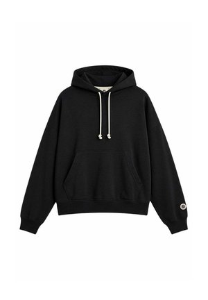 Sudadera negra con cordones blancos, bolsillo tipo canguro en el frente, puños acanalados y una pequeña etiqueta redonda con logo en el puño de la manga izquierda.