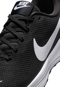 Zapatilla de running Nike negra con parte superior de malla texturizada, logo Swoosh blanco, cordones negros y suela blanca acolchada.