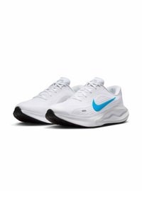 Witte sportieve schoenen met een gestructureerde mesh bovenkant en een gevoerde kraag. Voorzien van een opvallende blauwe Nike swoosh en een zwarte rubberen zool.