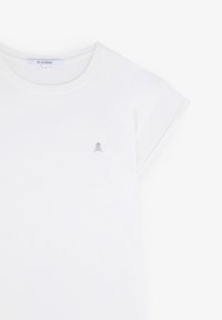 T-shirt bianco in cotone con maniche corte arrotolate, con un piccolo logo grigio sul petto. Collo rotondo, texture liscia.