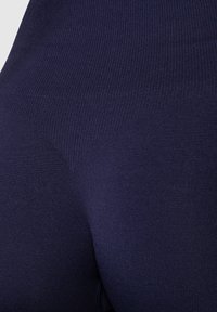 Leggings blu navy realizzati in un tessuto a coste elastico con una texture liscia, caratterizzati da una vita alta e un design aderente.