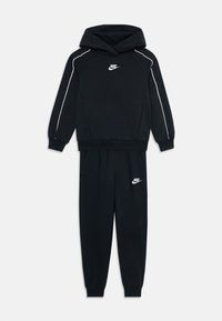 Ensemble hoodie et joggers noir Nike avec des piping blancs sur les manches et des logos sur la poitrine et la cuisse gauche.
