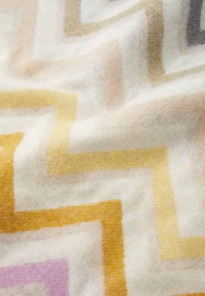 Woven fabric featuring a zigzag pattern in soft colors: yellow, beige, and light lavender, with a textured, plush surface.