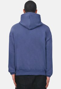 Kapuzensweatshirt in Blau, mit lockerer Passform, gerippten Bündchen und Saum sowie einer weichen Textur. Minimalistisches Design ohne sichtbare Grafiken.