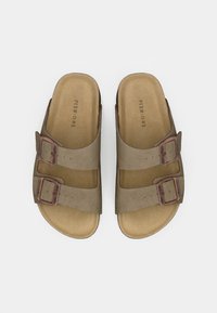 Sandales à enfiler en simili cuir marron avec deux boucles réglables, une semelle intérieure rembourrée et une semelle extérieure texturée.