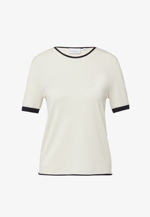 Kremowa bluzka z krótkim rękawem z czarną lamówką na kołnierzyku, krawędziach rękawów i dole, prezentowana na białym tle.