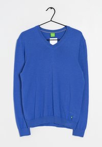 Blauer V-Ausschnitt-Pullover aus weichem Material, mit langen Ärmeln, gerippten Bündchen und Saum, und einem kleinen grünen Etikett an der unteren linken Seite.