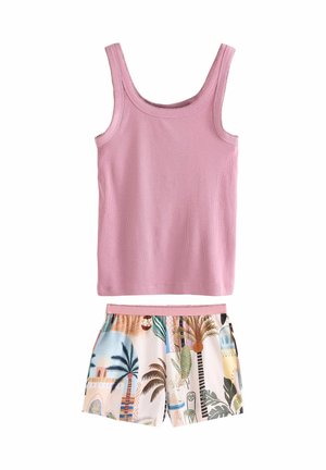 Top in cotone rosa a coste con scollo dritto abbinato a pantaloni corti a fantasia con disegni tropicali in colori pastello e una vita rosa.