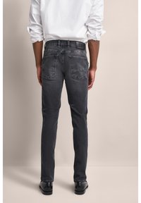 Jeans grigio scuro a gamba slim, con un classico design a cinque tasche e dettagli di cucitura sottili sulle tasche posteriori.
