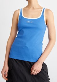 Blå randig tank top med vita detaljer och Nike-logotyp på bröstet. Har en figursydd design och fyrkantig halsringning, med smala axelremmar.