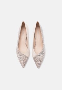 Paire de ballerines pointues en daim beige avec motif peau de serpent, vue de dessus sur fond blanc.