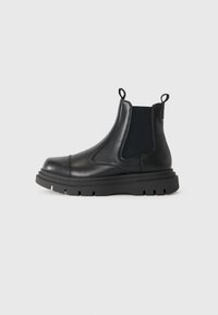 Black leather ankle boot with a chunky rubber sole, elastic side panels, and pull tabs for easy wear. Sleek design with minimal detailing.