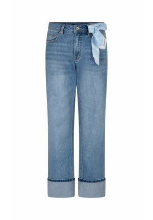 Lichtblauwe spijkerbroek met omslagen bij de zoom en een lichtblauwe sjaal met patroon vastgeknoopt aan de rechter riemlus.