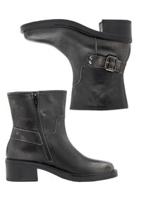 Bottines en cuir noir avec fermeture éclair latérale, talon bloc et sangle décorative avec boucle sur le côté extérieur.