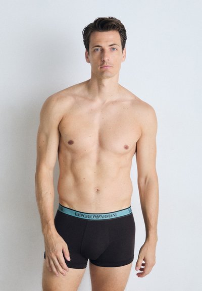 Boxeri negri din bumbac cu talie elastică, având branding turcoaz "Emporio Armani". Modelul are o poziție neutră pe un fundal deschis.