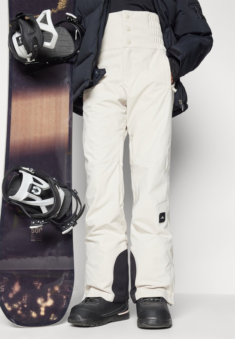 Spodnie snowboardowe w kolorze off-white z wysokim stanem, zatrzaskami i czarnymi akcentami. Gładki materiał z lekko teksturowanym pasem. Idealne do snowboardu.