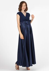 Raskas tummansininen äitiysmaksimekko, jossa on kietaisusuunnittelu, lyhyet hihat ja sidottava vyö. Sujuva, virtaava kangas luo elegantin siluetin.