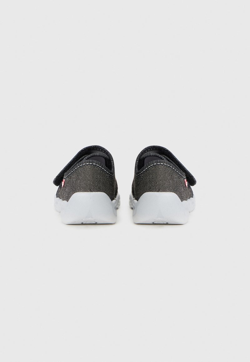 Schwarze Stoffschlupfschuhe mit grauen Gummisohlen, die eine strukturierte Oberfläche und eine Zuglasche an der Ferse für ein einfaches Anziehen bieten.