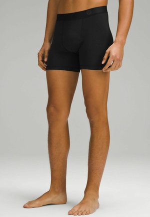 Schwarze Boxer-Briefs aus glattem, elastischem Stoff mit taillierter Passform. Mit einem elastischen, gebrandeten Bund und kurzer Beinlänge.