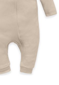 Beige Kinder-Overall aus weichem Stoff, mit einem Reißverschluss auf der Vorderseite, langen Ärmeln und Bündchen an den Fußknöcheln für eine bequeme Passform.