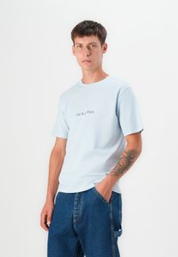 Light blue cotton t-shirt with a crew neckline and short sleeves, featuring the text "JACK & JONES" in dark lettering on the chest.