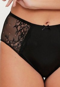 Culotte noire taille haute avec des panneaux en dentelle ornés d'un motif floral, un accent de nœud en satin à l'avant et une texture de tissu lisse.
