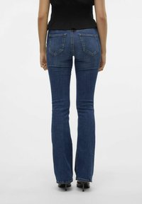 Uppsvängda blå jeans i en medelljus tvätt, tillverkade av denim. Har en klassisk femfickedesign, medelhög midja och sömmar längs sömmarna.