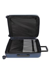 Valigia rigida, blu navy opaco, aperta con interno nero, due scomparti con zip, manico retrattile, quattro ruote per la mobilità.