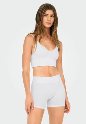 Ensemble composé d'un crop top côtelé blanc et d'un short, au design ajusté, avec des bords sans couture, une texture douce et un décolleté en V sur le haut.