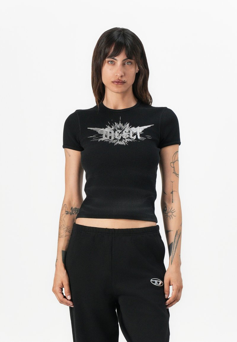 Black ribbed crop top featuring a silver graphic design with burst details on the front. Short sleeves, fitted silhouette, soft texture.