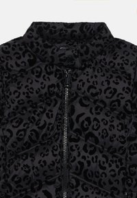 Black puffer jacket with a leopard print pattern. Features a standing collar and a central zipper. Material has a soft, textured finish.