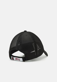 Gorra de béisbol de malla negra con visera curvada, que cuenta con una correa trasera etiquetada "BULLS" con un acento de logo. Textura ligera y diseño transpirable.