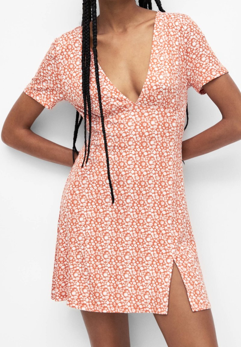 Vestido de manga corta en color naranja con un estampado floral, que cuenta con un profundo escote en V y una abertura lateral, hecho de una tela ligera para mayor comodidad.