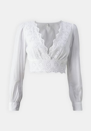 Valge lühikeste varrukatega pluus, millel on laineline v-kaelus ja broderie anglaise detailid ääredel. Sile kangas.
