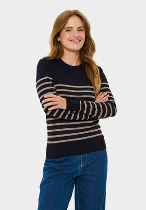 Marineblauer Pullover mit horizontalen beigen Streifen, Rundhalsauschnitt und gerippten Ärmelbündchen. Kombiniert mit hellblauen Jeans in entspannter Passform.
