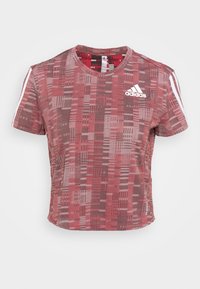 T-shirt rossa a maniche corte con motivo, dotata di collarino tondo, realizzata in tessuto leggero, con logo Adidas bianco e tre strisce bianche sulle spalle.
