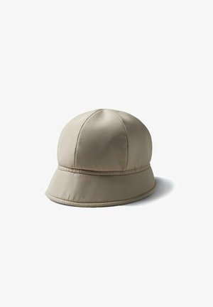 Chapeau seau matelassé beige avec un design à panneaux cousus et un bord légèrement évasé, présenté sur un fond blanc.