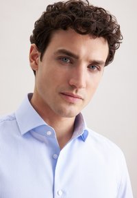 Camicia a righe azzurre e bianche con colletto classico, pattina con bottoni e una texture di tessuto liscia, caratterizzata da una vestibilità su misura e un aspetto ordinato.