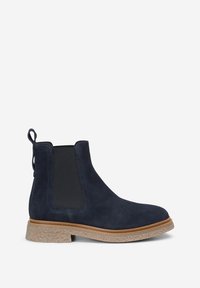 Botte Chelsea en daim bleu foncé avec panneau latéral élastique, languette à l'arrière et semelle en caoutchouc beige texturée.