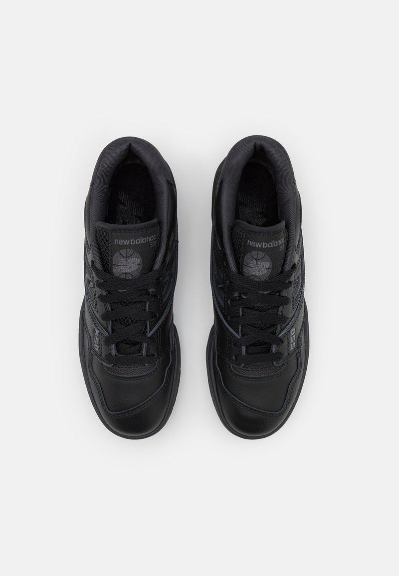 Baskets de sport noires avec une tige en cuir et en maille, présentant un bout arrondi, des lacets et une semelle extérieure texturée. Logo New Balance sur chaque chaussure.