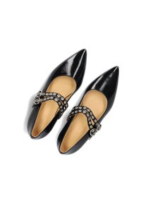 Zwarte gepatineerde leren schoenen met puntige neuzen en een tan kleurige binnenzool. Heeft een decoratieve band met ronde metalen accenten en uitsparingen.
