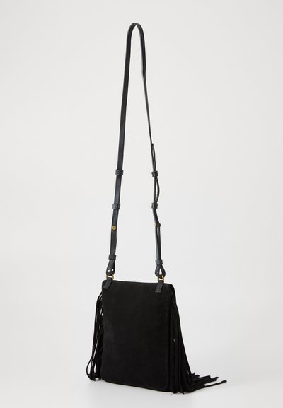 Sac à bandoulière en suede noir avec des franges sur les côtés, une sangle en cuir ajustable et des accents en métal doré.