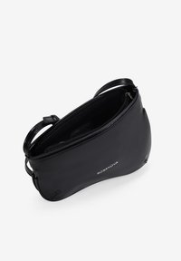 Bolso de mano de piel negra con forma curva, cierre de cremallera y correa para el hombro. Presenta una textura suave y un detalle de logo en relieve.