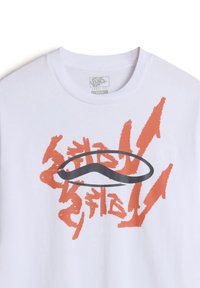 Camiseta blanca de corte holgado que presenta un atrevido gráfico naranja con diseños abstractos y un logotipo ovalado negro en el centro.