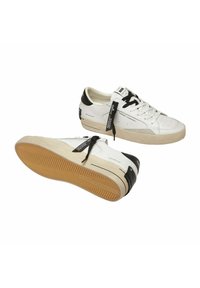 Baskets en cuir blanc avec des accents noirs, lacets plats, détails perforés et semelle en caoutchouc dotée d'un motif de grip texturé.